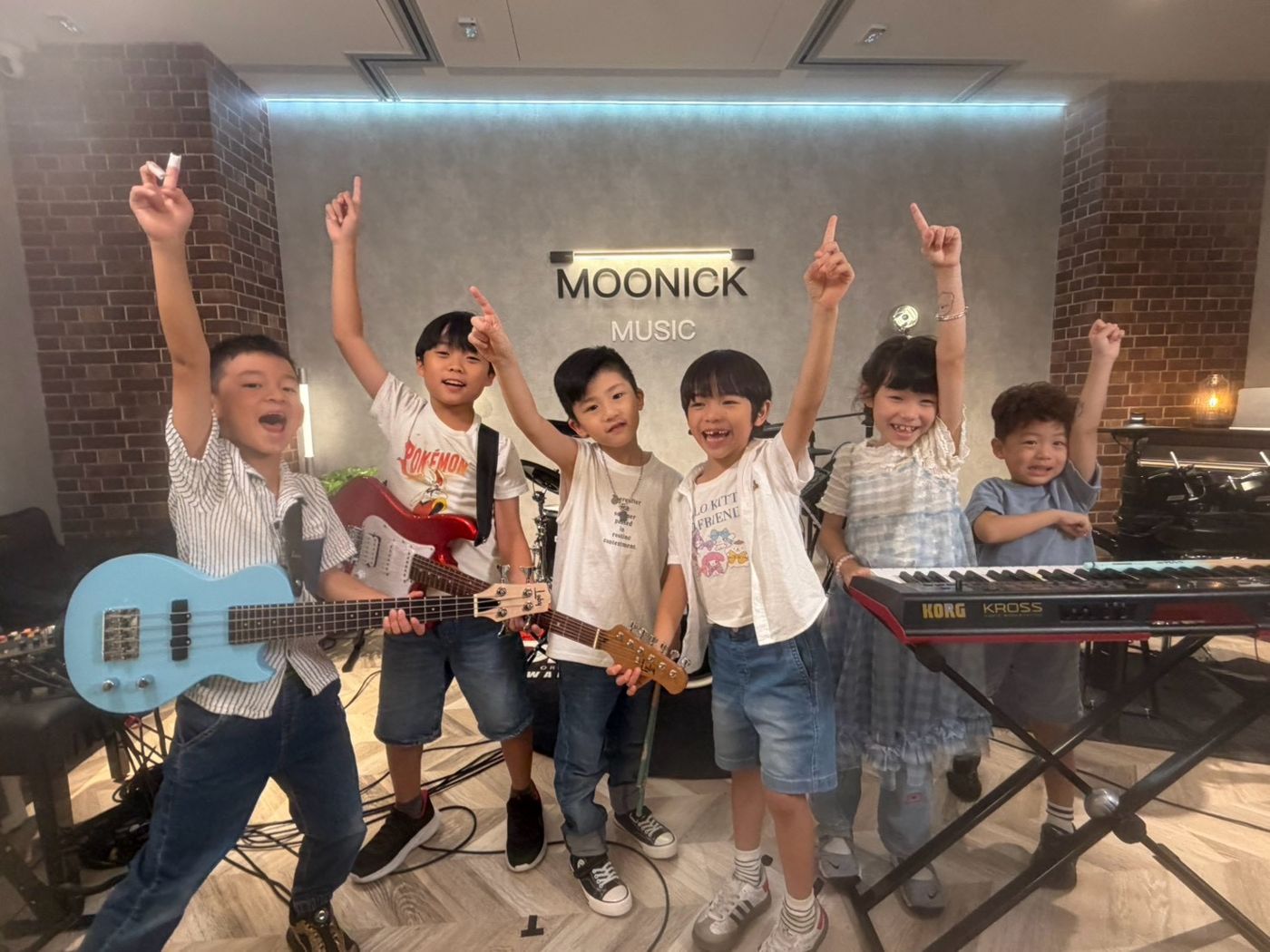 孩子們拿著吉他、鍵盤和 Bass 合奏